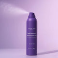 A purple aerosol can of Michael Todd Beauty Hair Identifier Spray is shown spraying against a purple background.